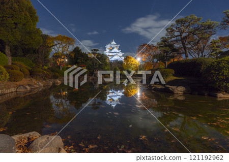 Night view of Osaka Castle's main tower reflected in the pond of Honmaru Japanese Garden 121192962