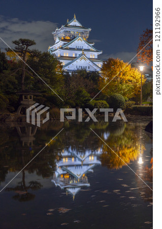 Night view of Osaka Castle's main tower reflected in the pond of Honmaru Japanese Garden 121192966