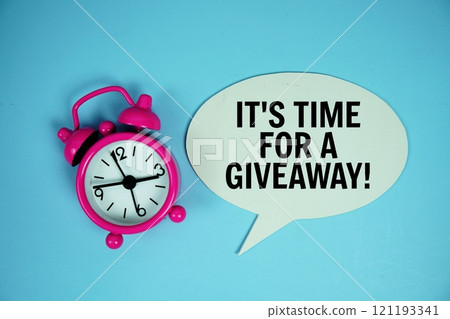 It's time for a giveaway text on speech bubble with alarm clock top view on blue background 121193341