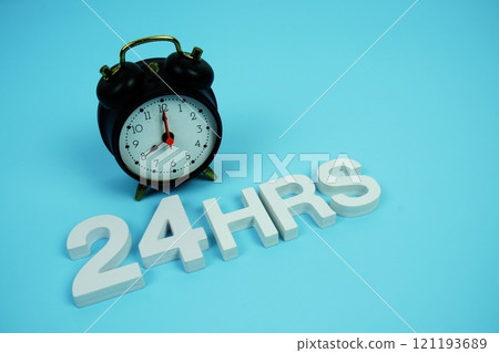 24 Hrs alphabet letters and alarm clock top view on blue background 24 Hrs alphabet letters and alarm clock top view on blue background 121193689