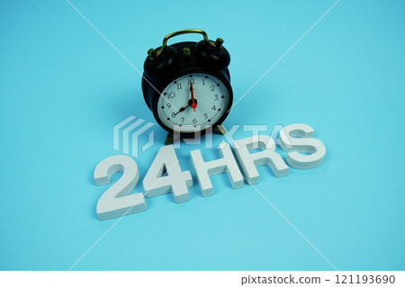 24 Hrs alphabet letters and alarm clock top view on blue background 24 Hrs alphabet letters and alarm clock top view on blue background 121193690