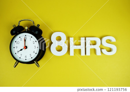 8 Hrs alphabet letters and alarm clock top view on yellow background 121193756