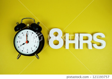 8 Hrs alphabet letters and alarm clock top view on yellow background 121193757