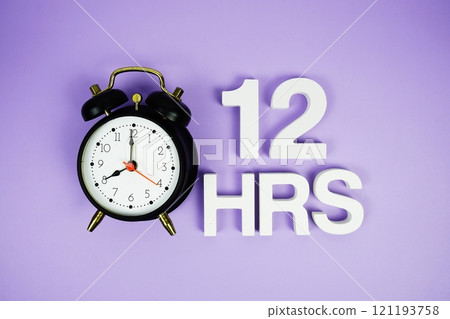 12 Hrs alphabet letters and alarm clock top view on purple background 121193758