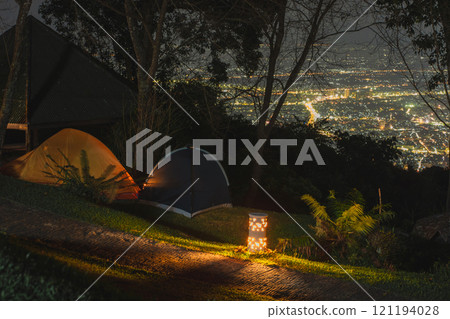 landscape and travel concept with man relax with camping tent on mountain and city background 121194028