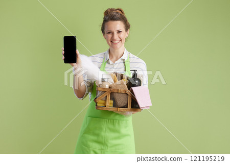 happy housewife using smartphone against green happy housewife using smartphone against green 121195219