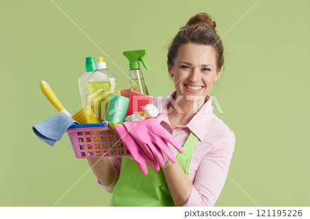 happy woman in green apron and rubber gloves isolated on green 121195226