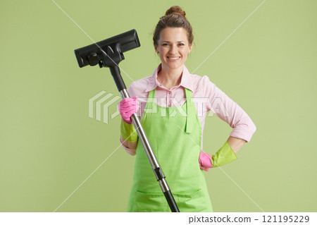 happy modern woman vacuum cleaner against green background 121195229