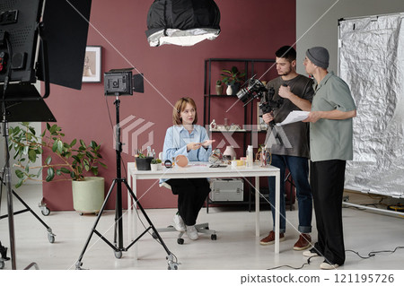 Studio with director chatting with actress while operator setting camera 121195726