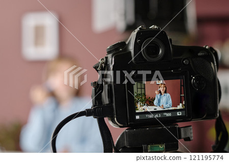 Medium close up of display with young actress powdering while sitting at table 121195774