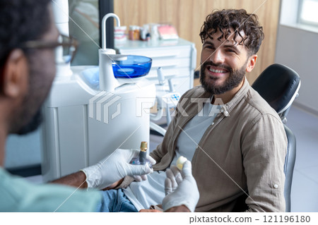 Man sitting in dentist chair during oral checkup i n clinic 121196180