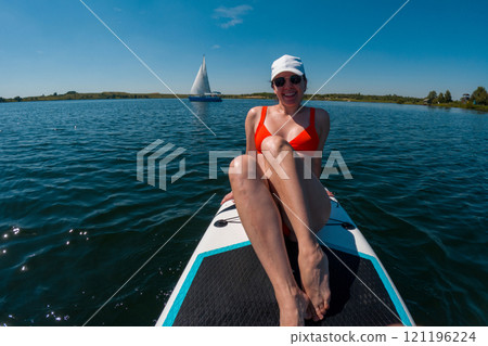 Woman Relaxing on Paddleboard in Summer Woman Relaxing on Paddleboard in Summer 121196224