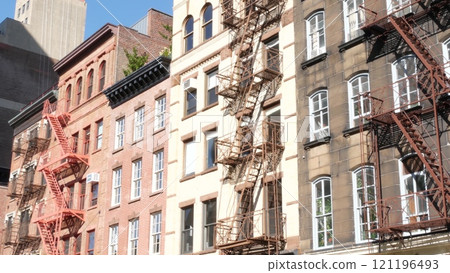 New York City building architecture, Manhattan. Residential house exterior. Red brick, fire escape. 121196493