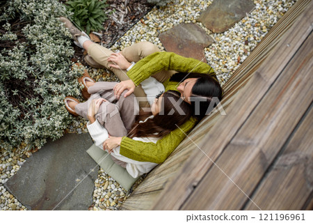 Portrait of beautiful mother with young daughter, sitting together and embracing. Portrait of beautiful mother with young daughter, sitting together and embracing. 121196961