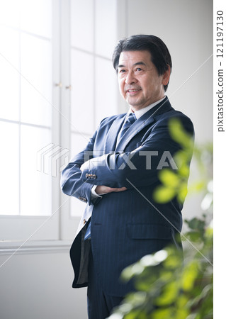 Vertical image of a smiling, positive senior executive or president with folded arms, business succession 121197130
