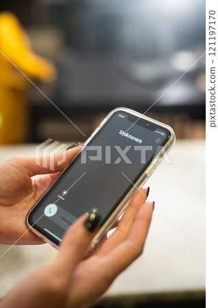 Fraud or fraudulent schemes. Close-up of a woman's hand holding a phone with an unexpected incoming call from an unknown person 121197170