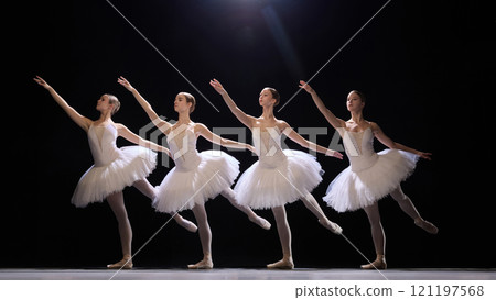 Elegant, young, beautiful girls, ballet dancer in classical white tutus performing in synchronized movements, dancing against dark background Elegant, young, beautiful girls, ballet dancer in classical white tutus performing in synchronized movements, dancing against dark background 121197568
