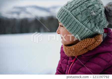Portrait of beautiful young girl looking at snowy nature around her. Portrait of beautiful young girl looking at snowy nature around her. 121197792