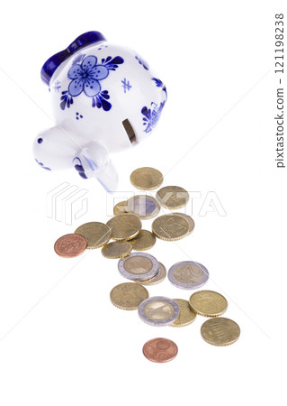 Piggy bank in a shape of a cow with blue ornament and scattered coins 121198238