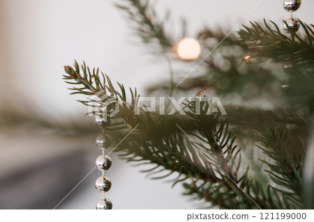 Elegant Close-Up of Christmas Tree Decorated with Silver Baubles and Green Pine Needles Elegant Close-Up of Christmas Tree Decorated with Silver Baubles and Green Pine Needles 121199000