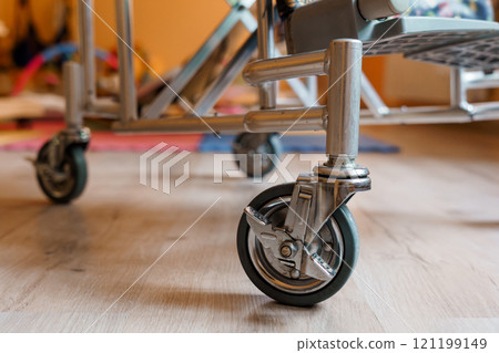 Close-Up of a Silver Metal Cart Wheel on a Wooden Floor Close-Up of a Silver Metal Cart Wheel on a Wooden Floor 121199149