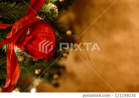 Festive Red Ornament on a Christmas Tree with Greenery and Gold Accents Festive Red Ornament on a Christmas Tree with Greenery and Gold Accents 121199238