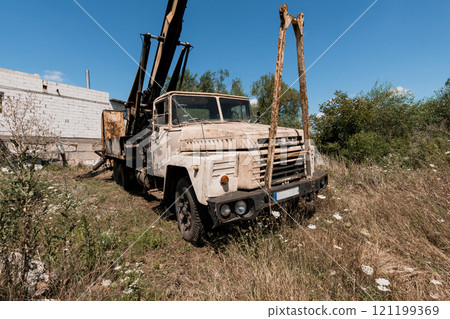 Abandoned Construction Truck Surrounded by Overgrown Vegetation Abandoned Construction Truck Surrounded by Overgrown Vegetation 121199369