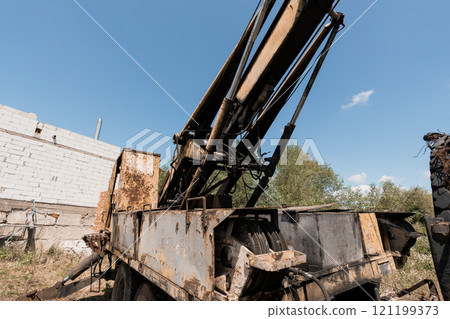 Rusty Crane Machinery in an Abandoned Construction Site Against a Blue Sky Rusty Crane Machinery in an Abandoned Construction Site Against a Blue Sky 121199373