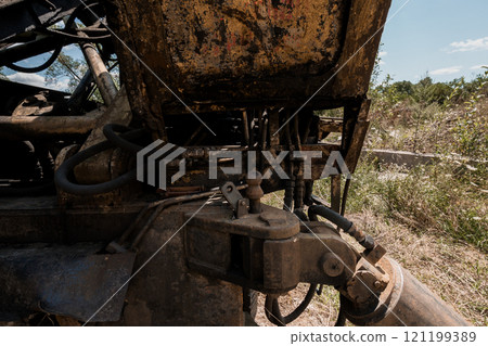 Rusted and Abandoned Hydraulic Machinery in Overgrown Landscape 121199389