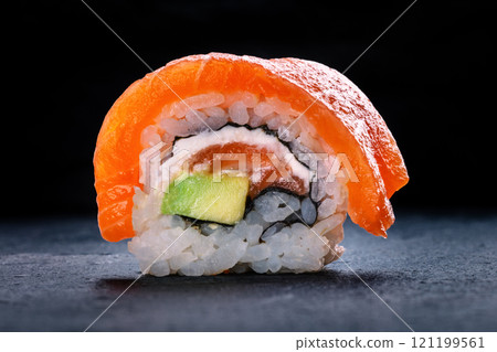 Salmon sushi with avocado and cream cheese, uramaki roll on a black background Salmon sushi with avocado and cream cheese, uramaki roll on a black background 121199561