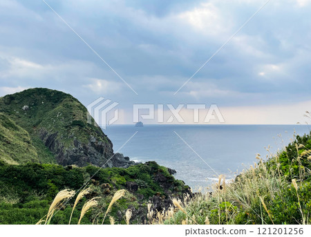 A tranquil view of green hills and the vast ocean A tranquil view of green hills and the vast ocean 121201256