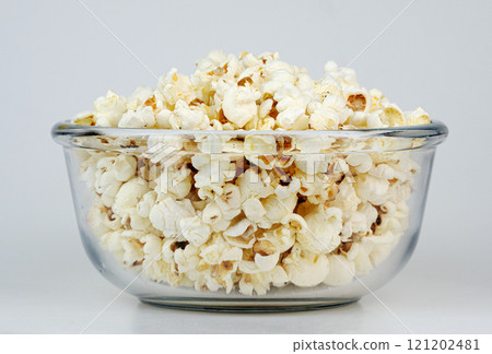 A clear glass bowl filled with fluffy, golden popcorn ready to be enjoyed A clear glass bowl filled with fluffy, golden popcorn ready to be enjoyed 121202481