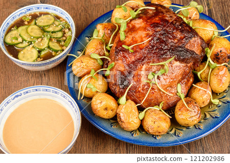 Baked meat with baby potatoes, mini green sprouts and cucumber sauces. 121202986