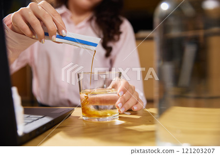 Woman dressed office attire pours liquid, medical preparation from sachet into water to remove intoxication. Treatment and medicine. Woman dressed office attire pours liquid, medical preparation from sachet into water to remove intoxication. Treatment and medicine. 121203207