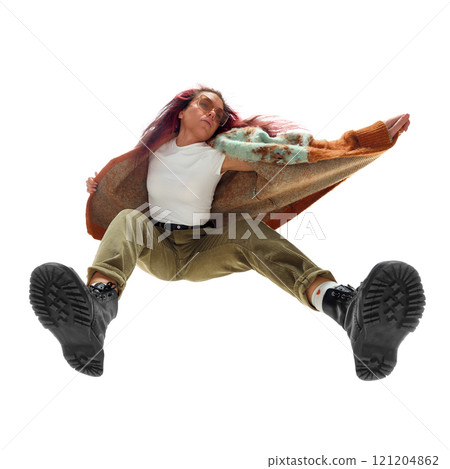 Low-angle bottom view image of young woman in colorful jacket and beige pants, captured mid-movement. Modern youth fashion. 121204862