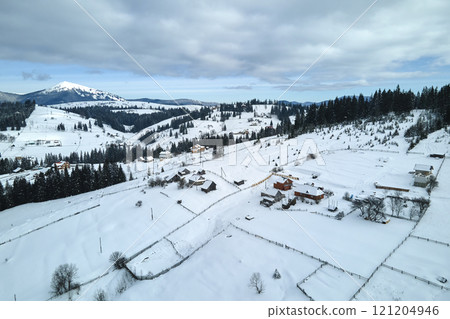 Winter landscape with small village houses between snow covered forest in cold mountains 121204946