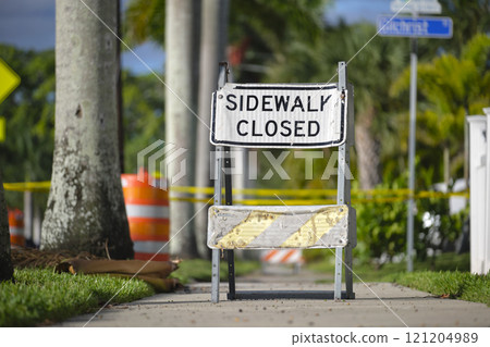 Warning sign that sidewalk is closed at street construction site. Utility work ahead 121204989