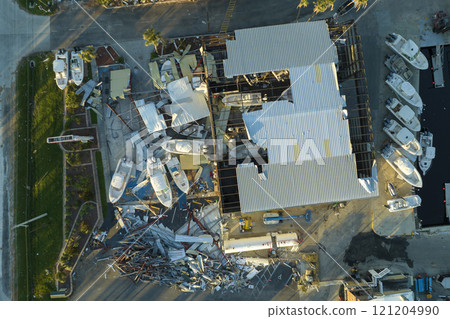 Warehouse with motorboats and yachts destroyed by hurricane winds in Florida coastal area. Natural disaster and its consequences 121204990