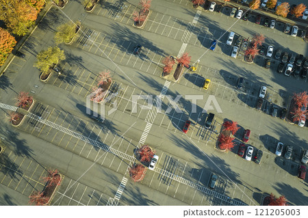 View from above of many parked cars on parking lot with lines and markings for parking places and directions. Place for vehicles in front of a strip mall center 121205003