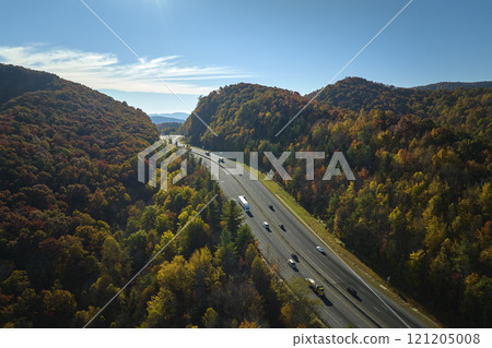 View from above of I-40 freeway in North Carolina heading to Asheville through Appalachian mountains in golden fall season with fast driving trucks and cars. Interstate transportation concept 121205008