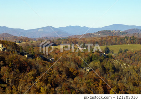 View from above of expensive residential houses high on hill top between yellow fall trees in suburban area in North Carolina. American dream homes as example of real estate development in US suburbs 121205010