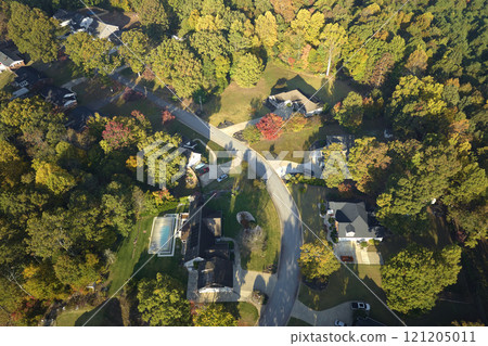 View from above of expensive residential houses between yellow fall trees in suburban area in South Carolina. American dream homes as example of real estate development in US suburbs 121205011