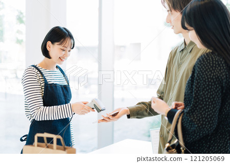 進行智能手機付款的夫婦 進行智能手機付款的夫婦 121205069