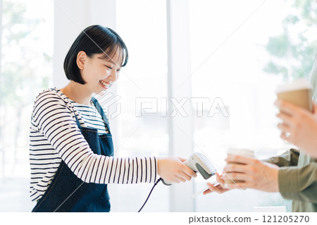 Female clerk processing smartphone payment 121205270