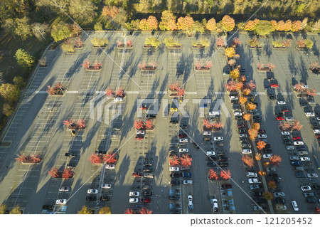Top view of many cars parked on a parking lot in front of a strip mall plaza. Concept of consumerism and market economy 121205452