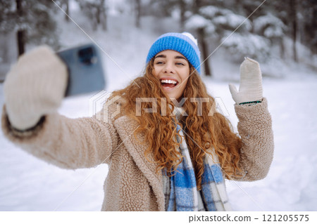 Happy female traveler with phone enjoying winter day outdoors. Christmas time. 121205575