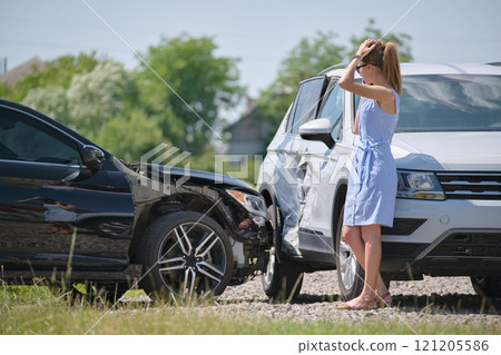 Sad female driver speaking on sellphone on street side calling for emergency service after car accident. Road safety and insurance concept Sad female driver speaking on sellphone on street side calling for emergency service after car accident. Road safety and insurance concept 121205586