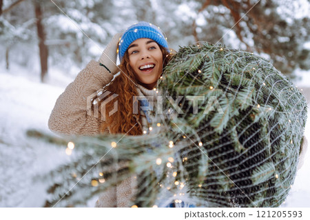 Smiling woman in a bright hat enjoying a winter day outdoors. Holiday, nature concept. Smiling woman in a bright hat enjoying a winter day outdoors. Holiday, nature concept. 121205593