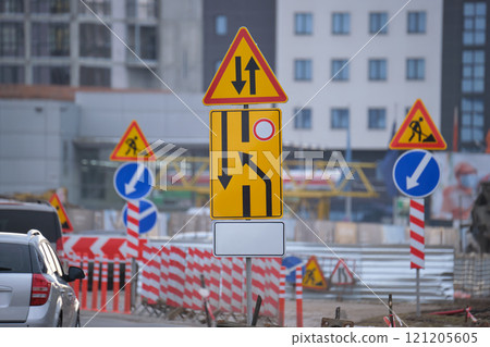 Roadworks warning traffic signs of construction work on city street and slowly moving cars 121205605
