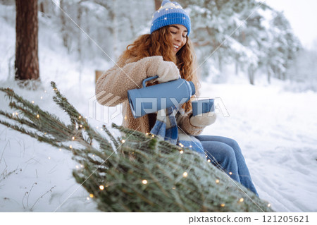 Smiling woman enjoying the Christmas atmosphere outdoors. Vacation concept. 121205621